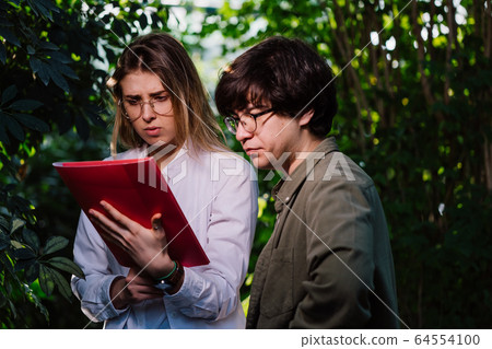 Young agricultural engineers working in greenhouse Young agricultural engineers working in greenhouse 64554100
