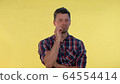 Close-up of handsome man promising to keep silence 64554414