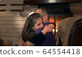 Happy father and small daughter embracing each other on armchair near the fireplace 64554418