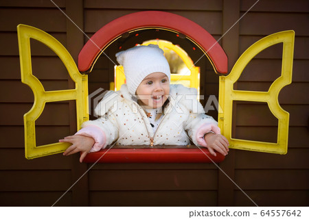 Funny portrait of baby girl looking through toy 64557642