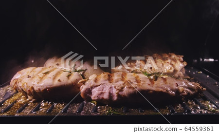 Delicious juicy meat steak cooking on the grill. Cook grilling fresh chicken breast. Fry chicken fillet on electric roaster. Slow motion. Delicious juicy meat steak cooking on the grill. Cook grilling fresh chicken breast. Fry chicken fillet on electric roaster. Slow motion. 64559361