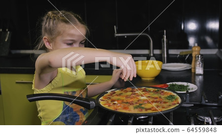 Smart girl learning to cook. Young mistress children to cook a Neapolitan egg fried omelette from salame affumicato sausage. Smart girl learning to cook. Young mistress children to cook a Neapolitan egg fried omelette from salame affumicato sausage. 64559848