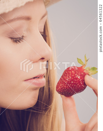Young woman with fresh strawberry 64561322