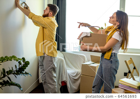 young caucasian married couple unpacking boxes at home young caucasian married couple unpacking boxes at home 64561693