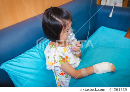 Sad asian child holds a mask vapor inhaler for treatment of asthma. Sad asian child holds a mask vapor inhaler for treatment of asthma. 64561889