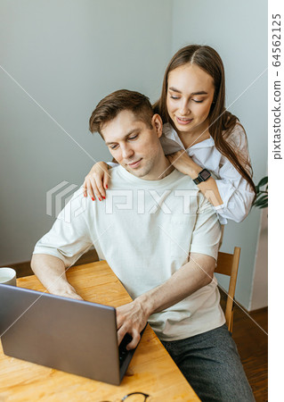 careful wife support her husband while he is working from home 64562125