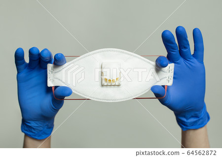 Filtering face piece mask in hand in doctor gloves 64562872