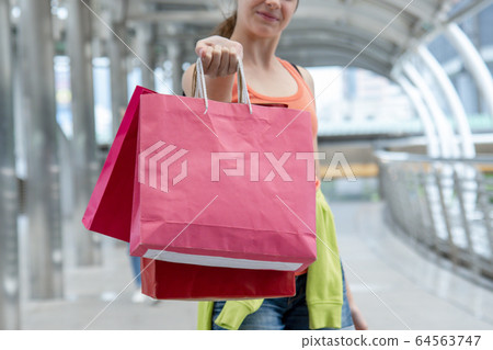 Shopaholic Women holding shopping bags ,money Shopaholic Women holding shopping bags ,money 64563747
