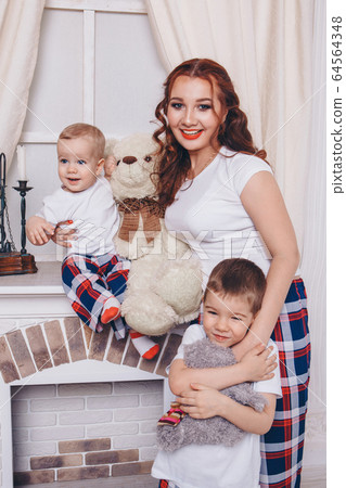Warming and relaxing by the fireplace. parents with their son's child hug. The concept of family, motherhood, interior, home, childhood, mother's Day, the day of protection of children 64564348