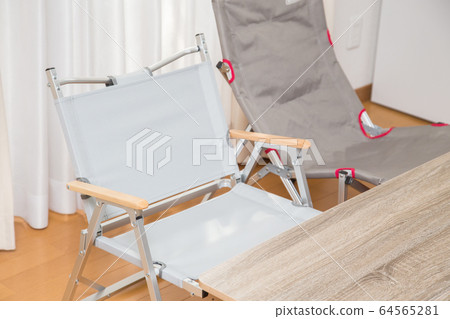 在屋子裡放一個露營椅和桌子 64565281