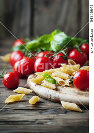 Raw intergal pasta with fresh tomato and basil Raw intergal pasta with fresh tomato and basil 64566641
