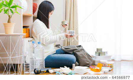 Women confirming canned items taken out disaster prevention copy space 16: 9 Women confirming canned items taken out disaster prevention copy space 16: 9 64566977