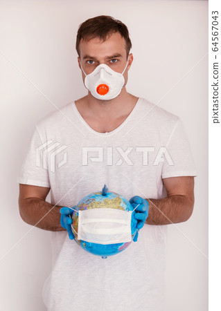 Man is holding globe in medical mask. Covid concept. Man is holding globe in medical mask. Covid concept. 64567043