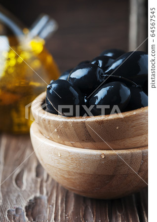 Black olive and olive oil on the wooden table Black olive and olive oil on the wooden table 64567545
