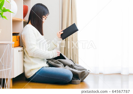 Woman copying wallet into purse Woman copying wallet into purse 64567787