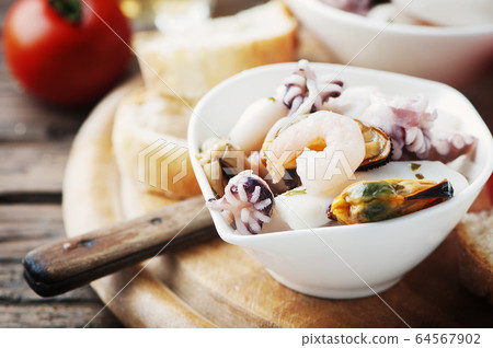 Seafood salad with white wine 64567902