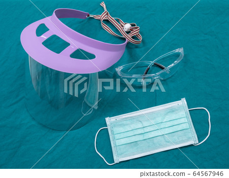 Group of protective headwear for Doctor and Nurse (such as surgical mask, face shield and safety glasses) before surgery in operating room. Conceptual of important objects in covid-19 outbreak. 64567946