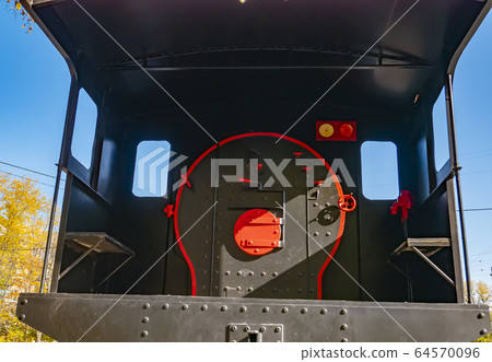 Cabin with the firebox of an old railway locomotive. 64570096