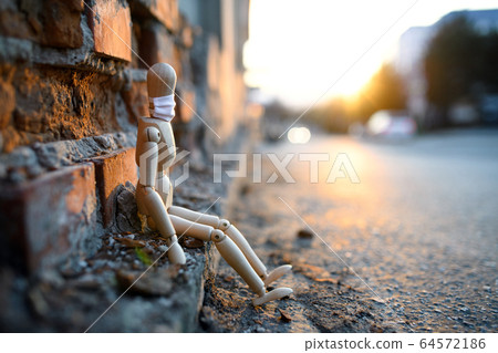 Sad and tired wooden mannequin in town, corona virus and lockdown concept. Sad and tired wooden mannequin in town, corona virus and lockdown concept. 64572186