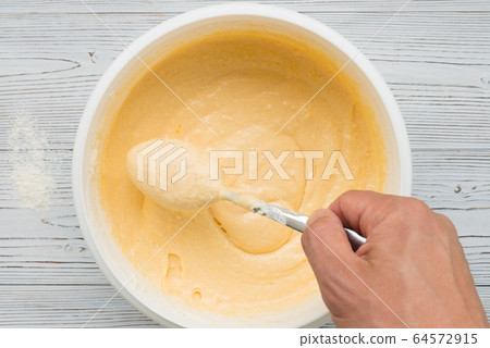liquid yellow pastry dough in bolw top view liquid yellow pastry dough in bolw top view 64572915