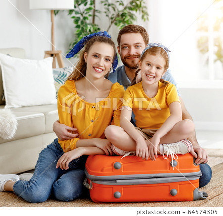 Happy parents with daughter on suitcase setting Happy parents with daughter on suitcase setting 64574305