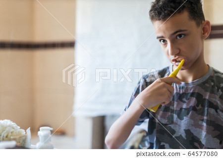 A young boy brushing his teeth 64577080