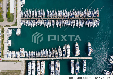 Croatia, marina Kastela, Drone view point on moored in an equal row sailboats, participant of a sailing regatta, piers, a lot of boats, mountains is on background, piers Croatia, marina Kastela, Drone view point on moored in an equal row sailboats, participant of a sailing regatta, piers, a lot of boats, mountains is on background, piers 64578046