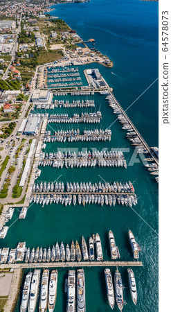 Croatia, marina Kastela, 15 September 2019: Drone view point on moored in an equal row sailboats, participant of a sailing regatta, piers, a lot of boats, mountains is on background, piers 64578073