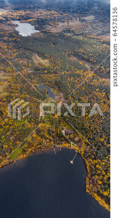Drone view point of rural area in Autumn with lake Boroye, The big wooden house in forest, Piers on the lake, Valday national park, Russia, panoramic image, golden trees, Wooden lodges, cloudy weather Drone view point of rural area in Autumn with lake Boroye, The big wooden house in forest, Piers on the lake, Valday national park, Russia, panoramic image, golden trees, Wooden lodges, cloudy weather 64578136