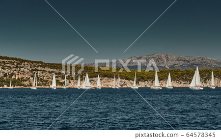 Beautiful sea landscape with sailboats, the race of sailboats on the horizon, a regatta, a Intense competition, bright colors, island with windmills are on background 64578345