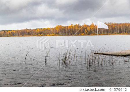 The Long pier on the lake, the Autumn at the lake Boroye, Valday national park, Russia, slow motion video, golden trees are on a background, wooden lodges, cloudy weather The Long pier on the lake, the Autumn at the lake Boroye, Valday national park, Russia, slow motion video, golden trees are on a background, wooden lodges, cloudy weather 64579642