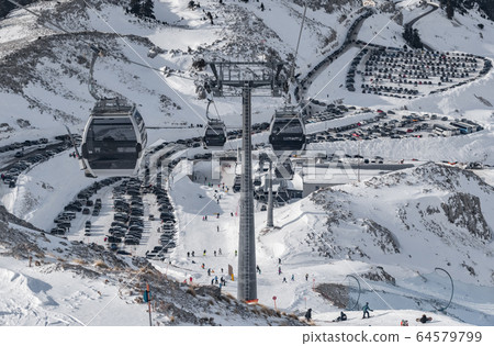 The famous snowed mountain of Parnassos with popular ski resort covered up in snow and unique nature, cable cabins, car parking, Voiotia, Greece The famous snowed mountain of Parnassos with popular ski resort covered up in snow and unique nature, cable cabins, car parking, Voiotia, Greece 64579799