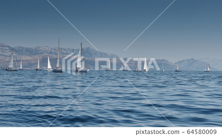 Beautiful sea landscape with sailboats, the race of sailboats on the horizon, a regatta, a Intense competition, bright colors, island with windmills are on background Beautiful sea landscape with sailboats, the race of sailboats on the horizon, a regatta, a Intense competition, bright colors, island with windmills are on background 64580009