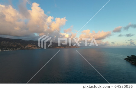 France, Saint-Jean-Cape-Ferrat, 15 December 2019: Aerial view of most expensive place in French Riviera at sunset, terraces of country houses and estates, pools, Chaise lounges, pink clouds France, Saint-Jean-Cape-Ferrat, 15 December 2019: Aerial view of most expensive place in French Riviera at sunset, terraces of country houses and estates, pools, Chaise lounges, pink clouds 64580036