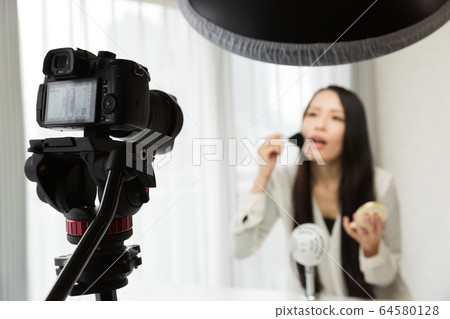 A woman shooting a video with an SLR camera A woman shooting a video with an SLR camera 64580128