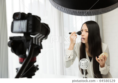 A woman shooting a video with an SLR camera A woman shooting a video with an SLR camera 64580129