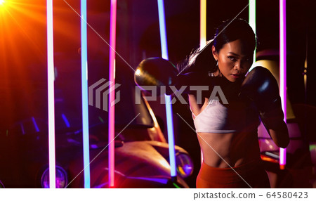 Woman trains exercise Boxing boxer neon modern gym Woman trains exercise Boxing boxer neon modern gym 64580423