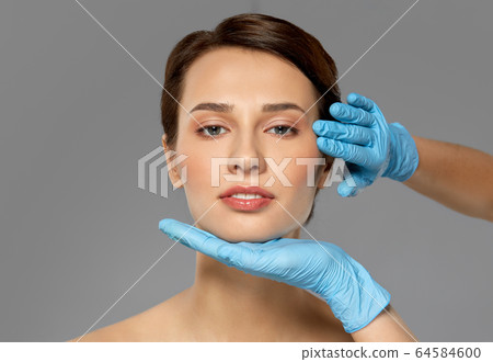 beautiful young woman face and hand in gloves beautiful young woman face and hand in gloves 64584600