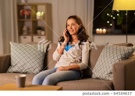 happy young woman calling on smartphone at home happy young woman calling on smartphone at home 64584637