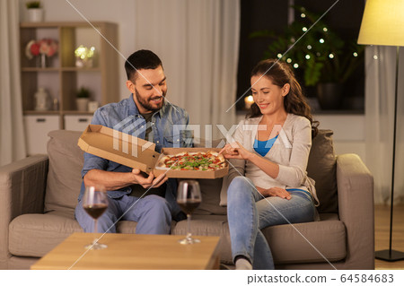 happy couple eating takeaway pizza at home happy couple eating takeaway pizza at home 64584683