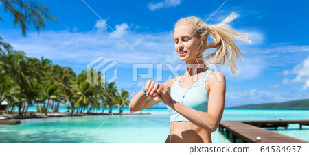 happy woman with fitness tracker and earphones happy woman with fitness tracker and earphones 64584957