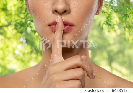 beautiful young woman holding finger on lips beautiful young woman holding finger on lips 64585151