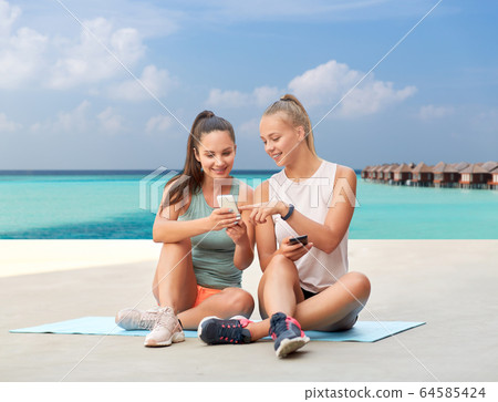 sporty women or friends with smartphone oves sea sporty women or friends with smartphone oves sea 64585424