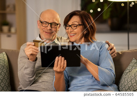 happy senior couple with tablet pc and credit card 64585505