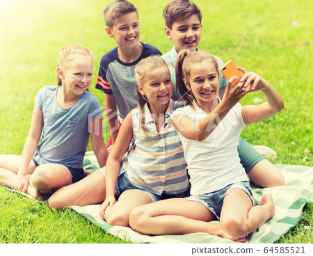 happy kids or friends taking selfie in summer park happy kids or friends taking selfie in summer park 64585521