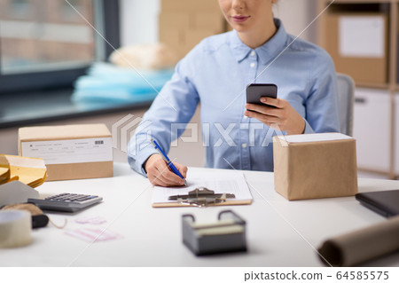 woman with smartphone and clipboard at post office woman with smartphone and clipboard at post office 64585575
