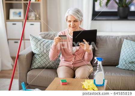 old woman with tablet pc and credit card at home old woman with tablet pc and credit card at home 64585819
