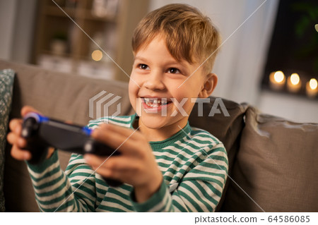 little boy with gamepad playing video game at home little boy with gamepad playing video game at home 64586085