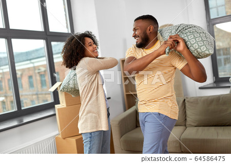 happy couple having pillow fight at new home happy couple having pillow fight at new home 64586475