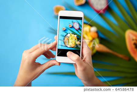 hands taking photo of exotic fruits on smartphone hands taking photo of exotic fruits on smartphone 64586478